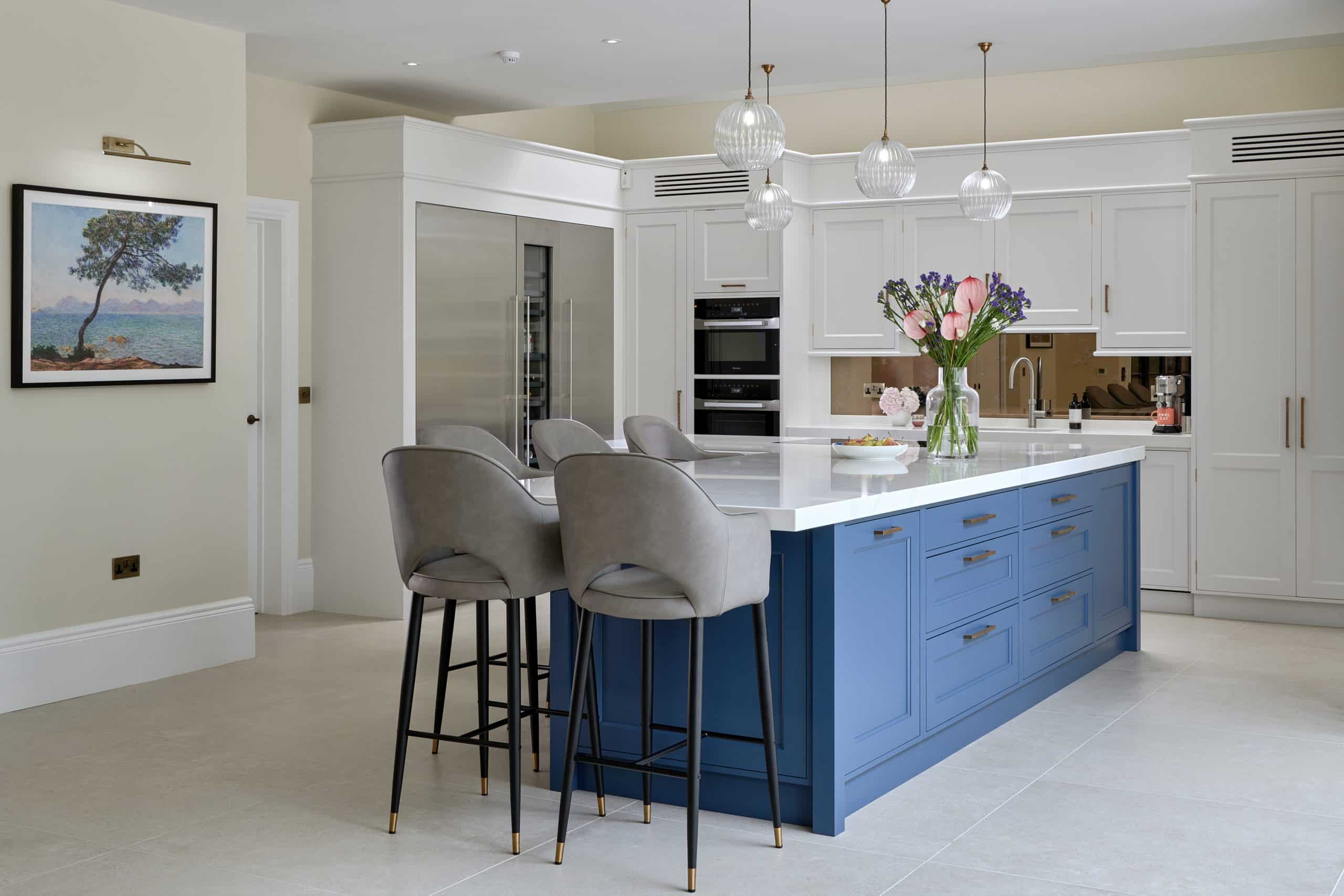 Large blue kitchen island with seating and storage and lighting.